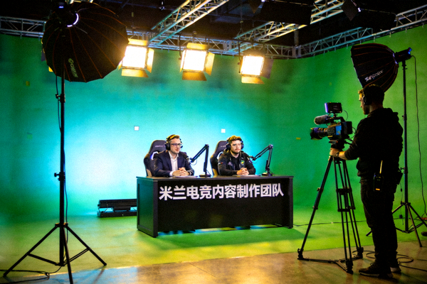 米兰电竞内容制作团队正在绿幕影棚中录制电竞解说节目，摄影师调整机位角度