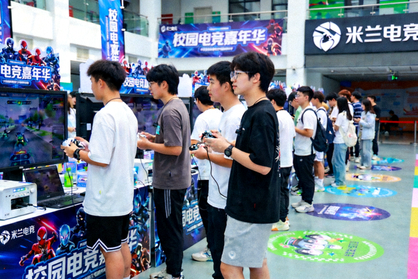 米兰电竞与高校联合举办的校园电竞嘉年华，大学生们在社团展台旁体验竞技互动游戏